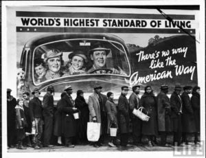 Foto satirizando as oportunidades da economia americana. Em frente a outdoor do american way of life uma fila de desempregados.