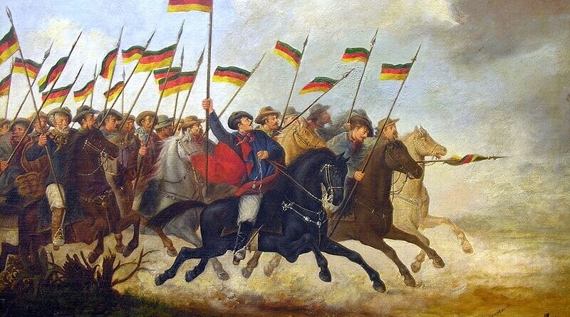 Imagem mostrando cavalos correndo em posição de ataque com cavalariços portando bandeiras da revola dos farrapos.